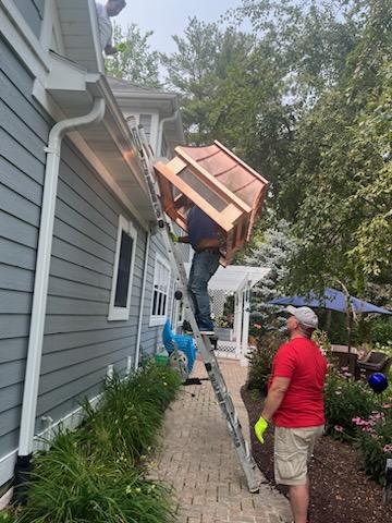 Contractor carrying custom copper chimney cap up ladder for installation — Archaic Metal fabricated cap delivered direct to chimney sweep