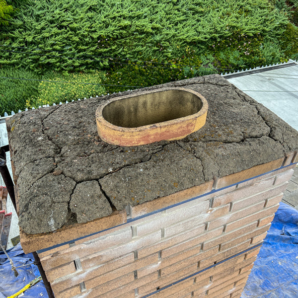 Severely cracked chimney crown on brick masonry chimney — no cap installed