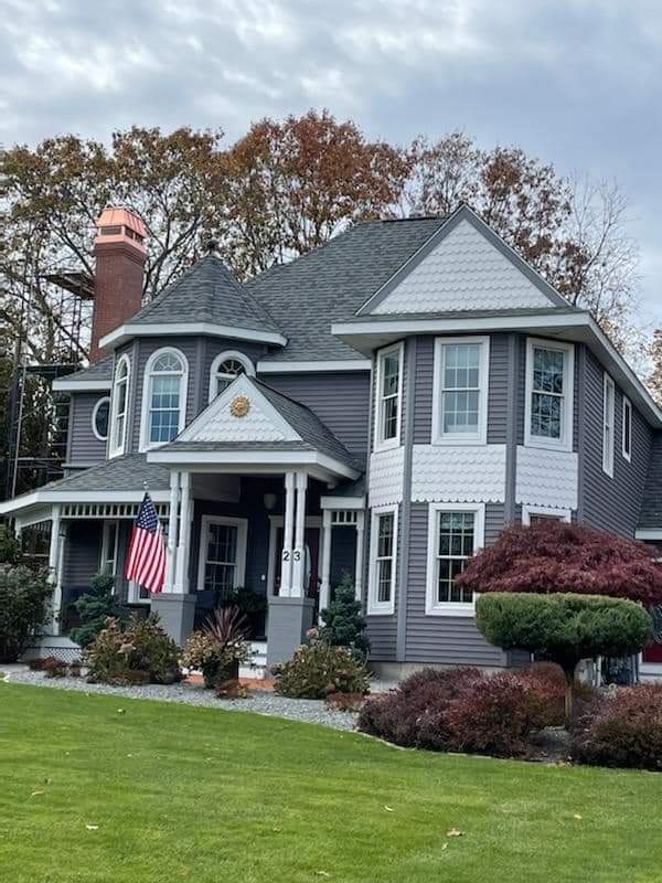 Residential home with copper chimney cap on roofline — schedule chimney cap installation before spring landscaping season