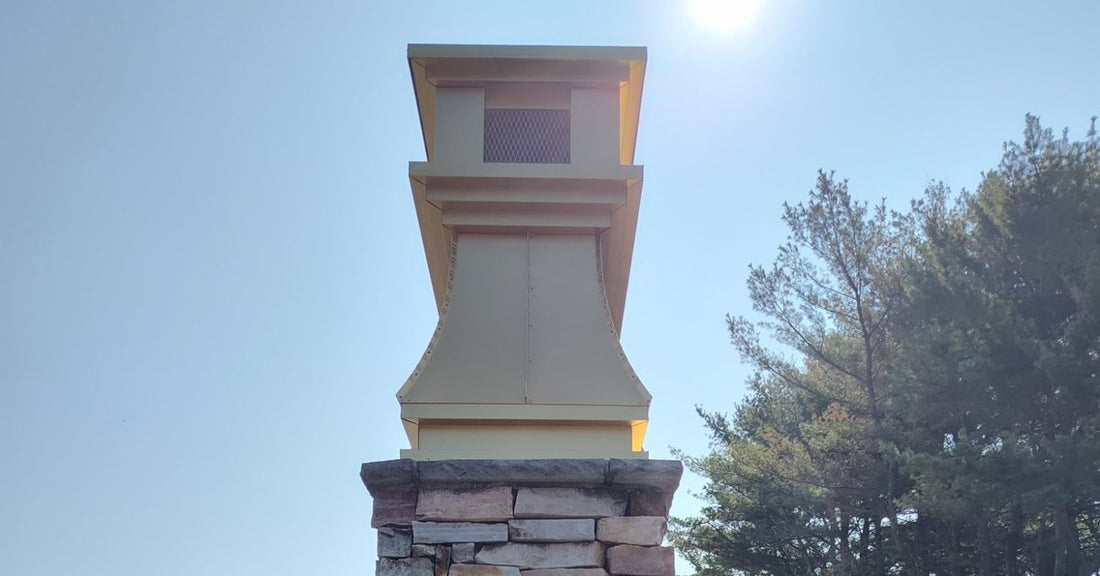 Gold anodized aluminum curved panel chimney cap installed on stone chimney — custom fabricated by Archaic Metal, Berlin NJ