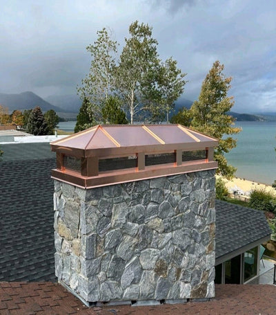 Custom copper hip and ridge chimney cap hand-fabricated to exact flue dimensions