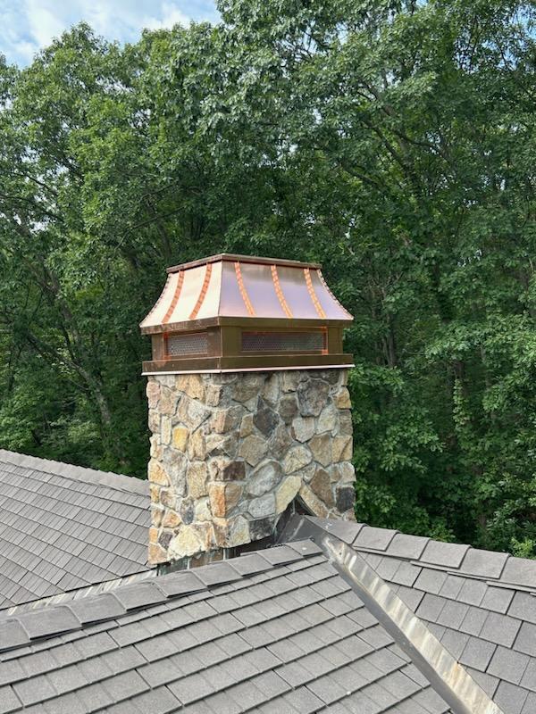 Custom copper curved panel chimney cap with decorative standing seam detail on stone masonry chimney — hand-fabricated by Archaic Metal