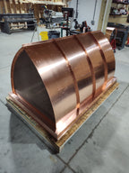 Large custom curved panel chimney cap in 16oz copper — concave mansard profile with riveted copper panels and stainless steel spark screen, fabricated in the Archaic Metal shop in Berlin, NJ