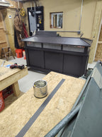 Kynar black board and batten top vent cap, single-flue size, front view on workbench