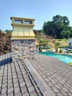 Kynar crown top vent cap installed on stone chimney with pool in background — Archaic Metal