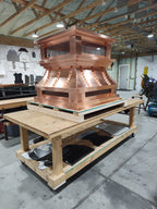 Large multi-flue copper crown top vent chimney cap on workbench, front view