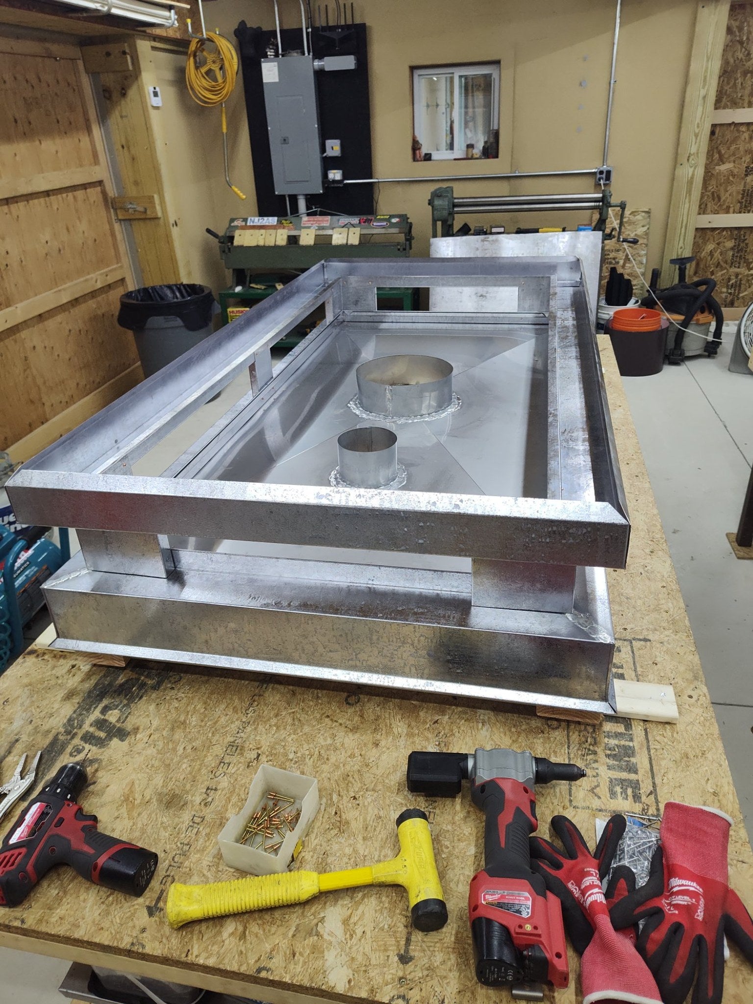 Custom crown top vent chimney cap base in fabrication, showing flue collar penetrations