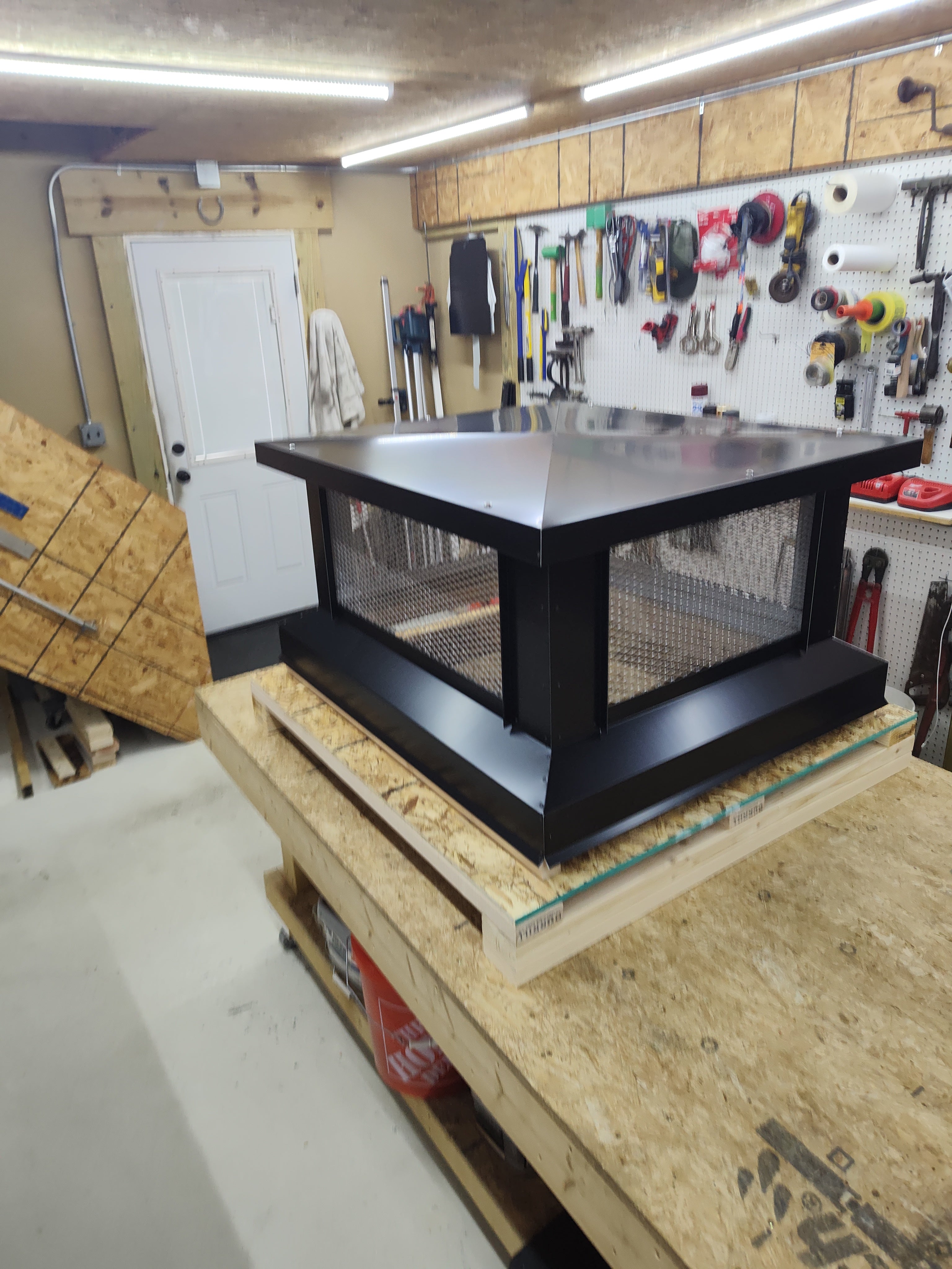 Large multi-flue chimney cap front view — black Kynar aluminum with stainless mesh, shop fabrication