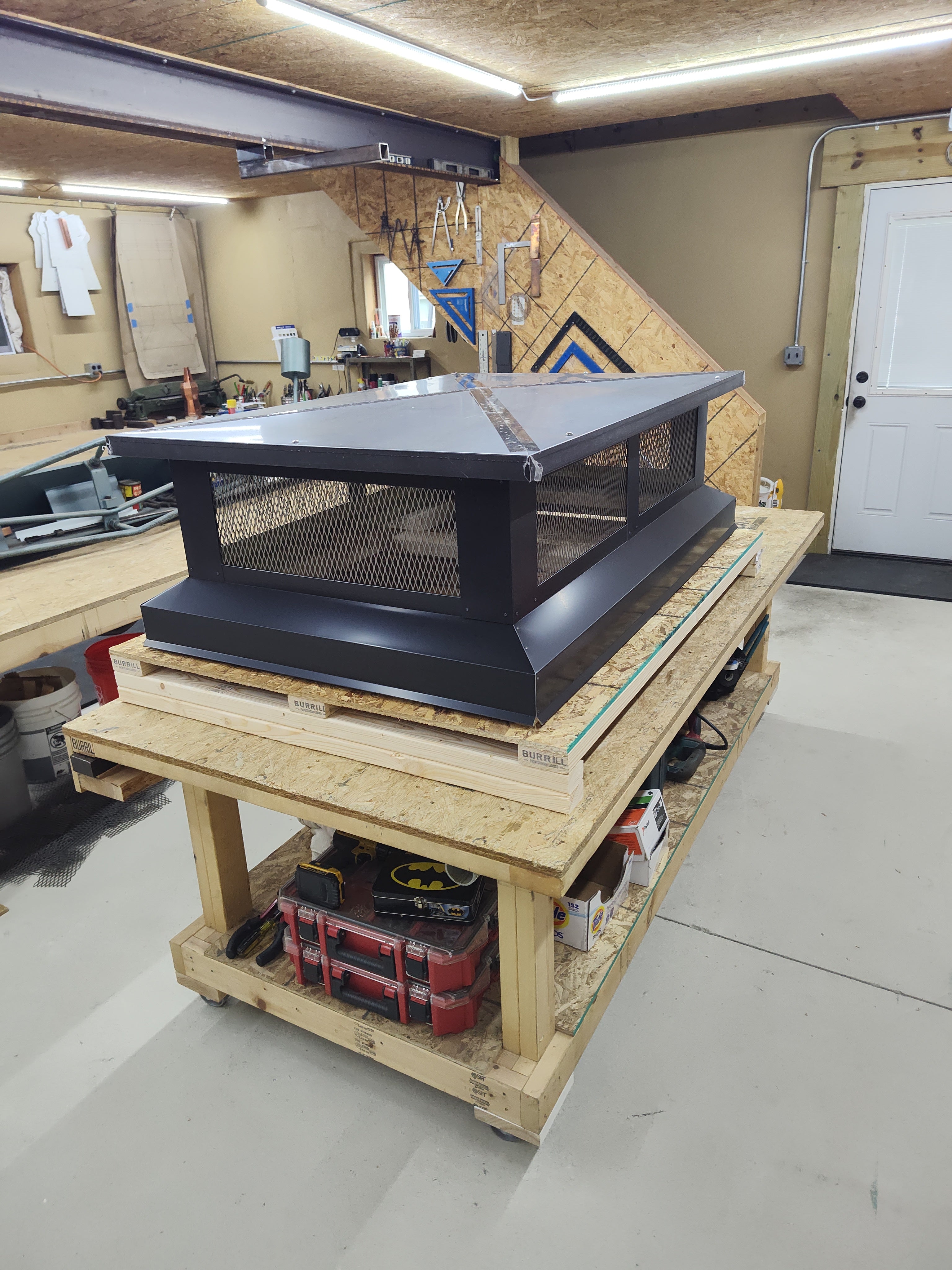 Custom multi-flue cap with hip top lid in black Kynar — front view showing mesh screen panels