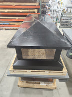 Multi-flue chimney cap in fabrication shop — shows scale against workshop equipment