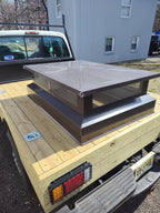 Custom multi-flue chimney cap loaded for delivery — black Kynar aluminum flat top design