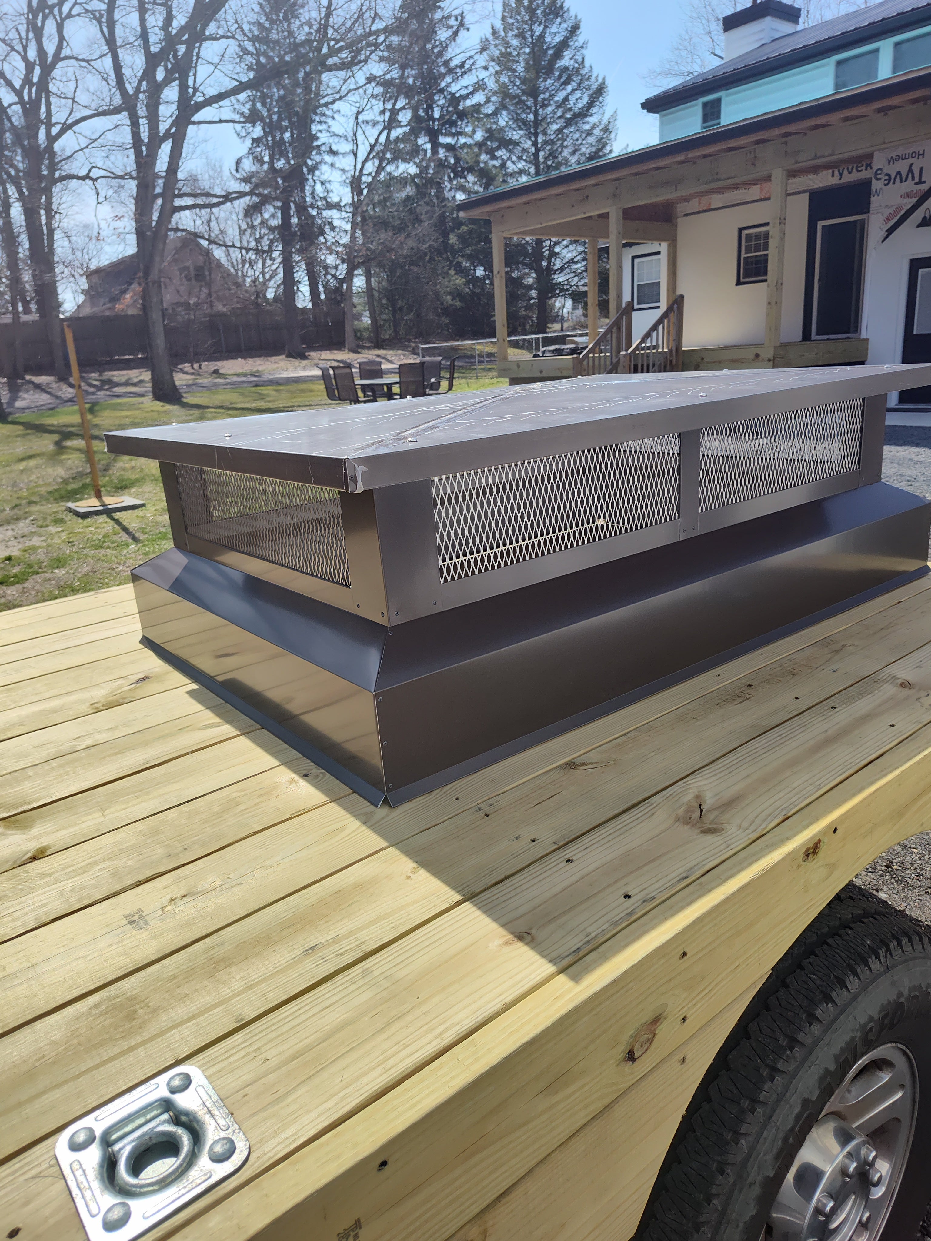 Custom multi-flue chimney cap installed — black Kynar aluminum, rooftop view