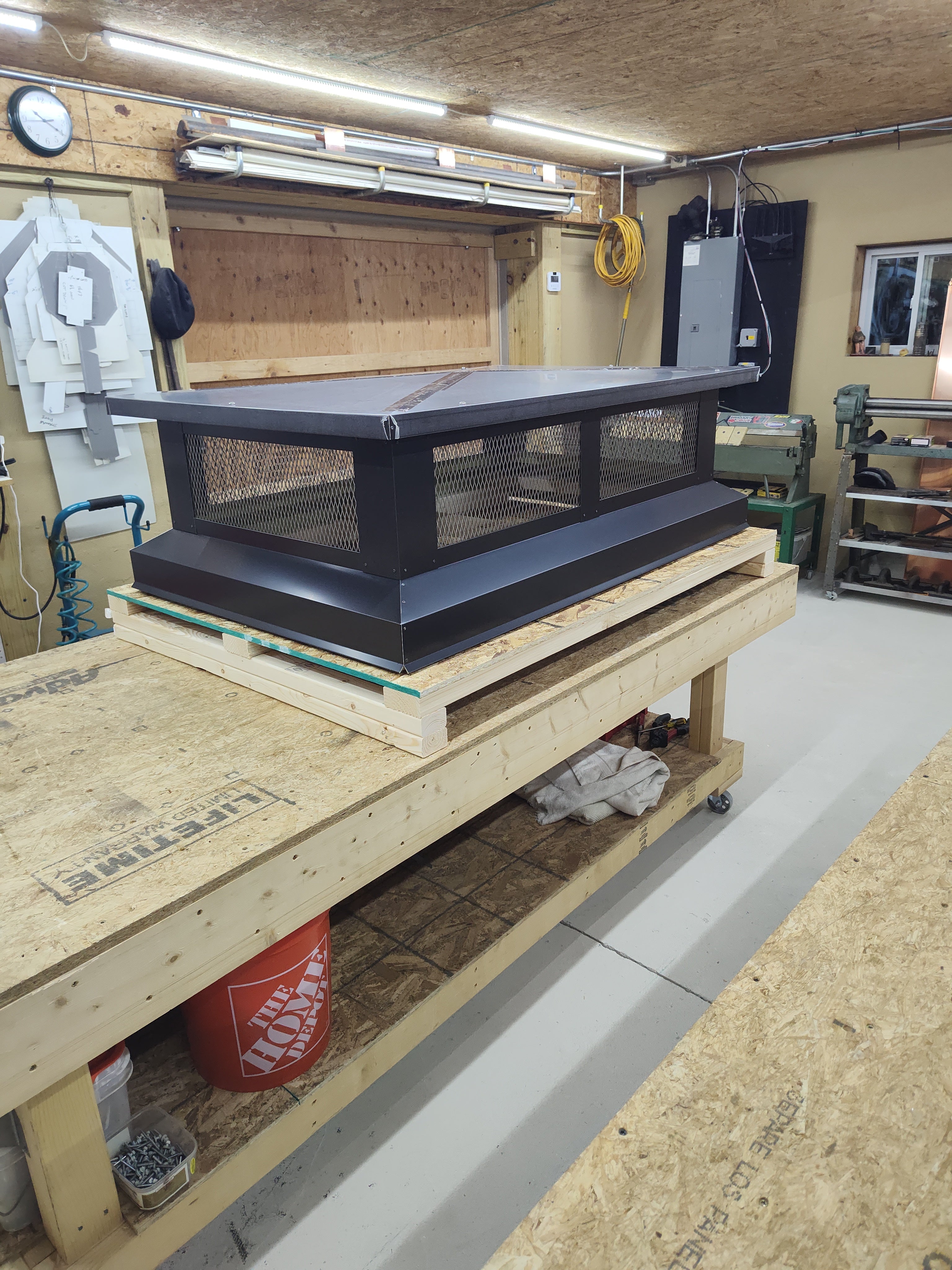 Multi-flue chimney cap installed on rooftop — wide profile flat top design in black Kynar