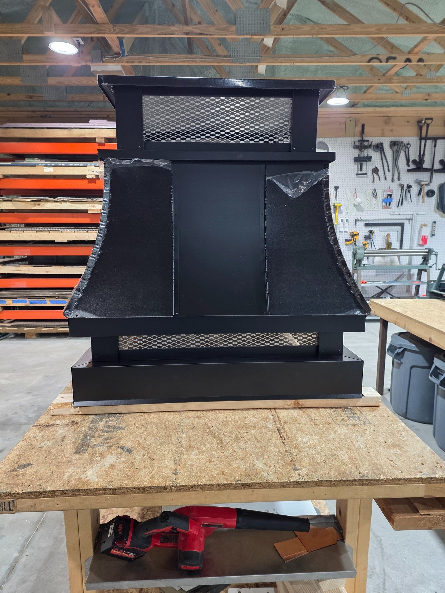 Kynar black top vent curved panel chimney cap, single-flue, front view on workbench