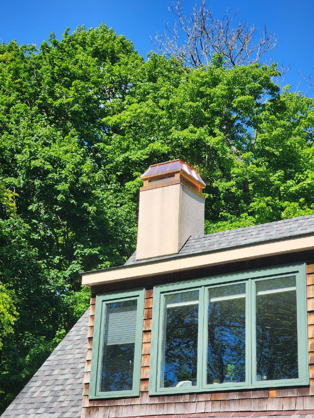 Custom copper chimney cap on stucco wood-framed chase above dormer roofline — hand-fabricated by Archaic Metal