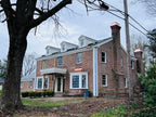 Two custom copper chimney caps installed on brick colonial home — hand-fabricated by Archaic Metal