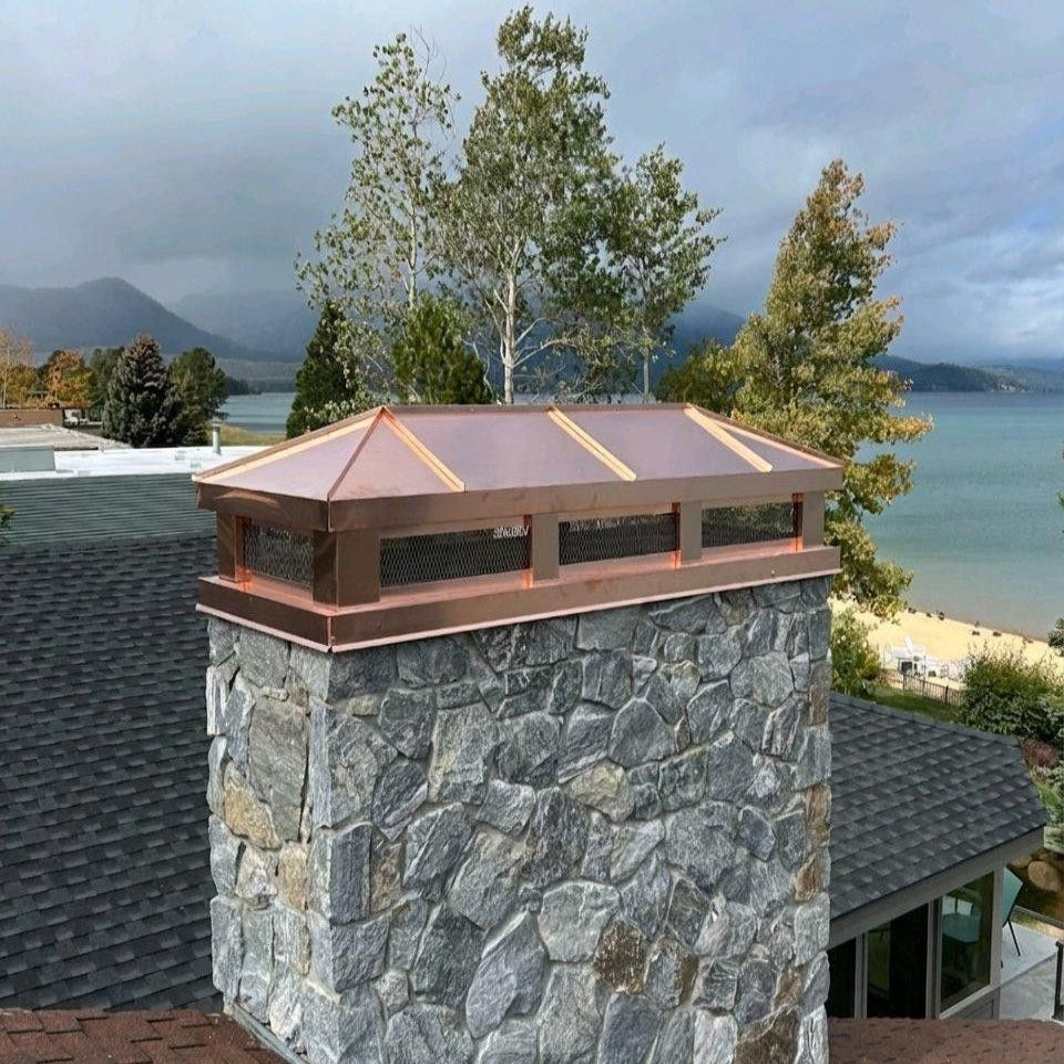 Custom copper hip and ridge chimney cap installed on stone chimney – Archaic Metal
