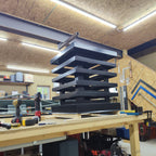 Custom louvered chimney caps stacked on fabrication bench — handbuilt to order at Archaic Metal