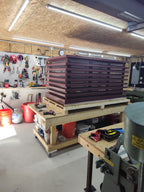 Custom louvered chimney caps in Kynar finish stacked in workshop — handcrafted by Archaic Metal