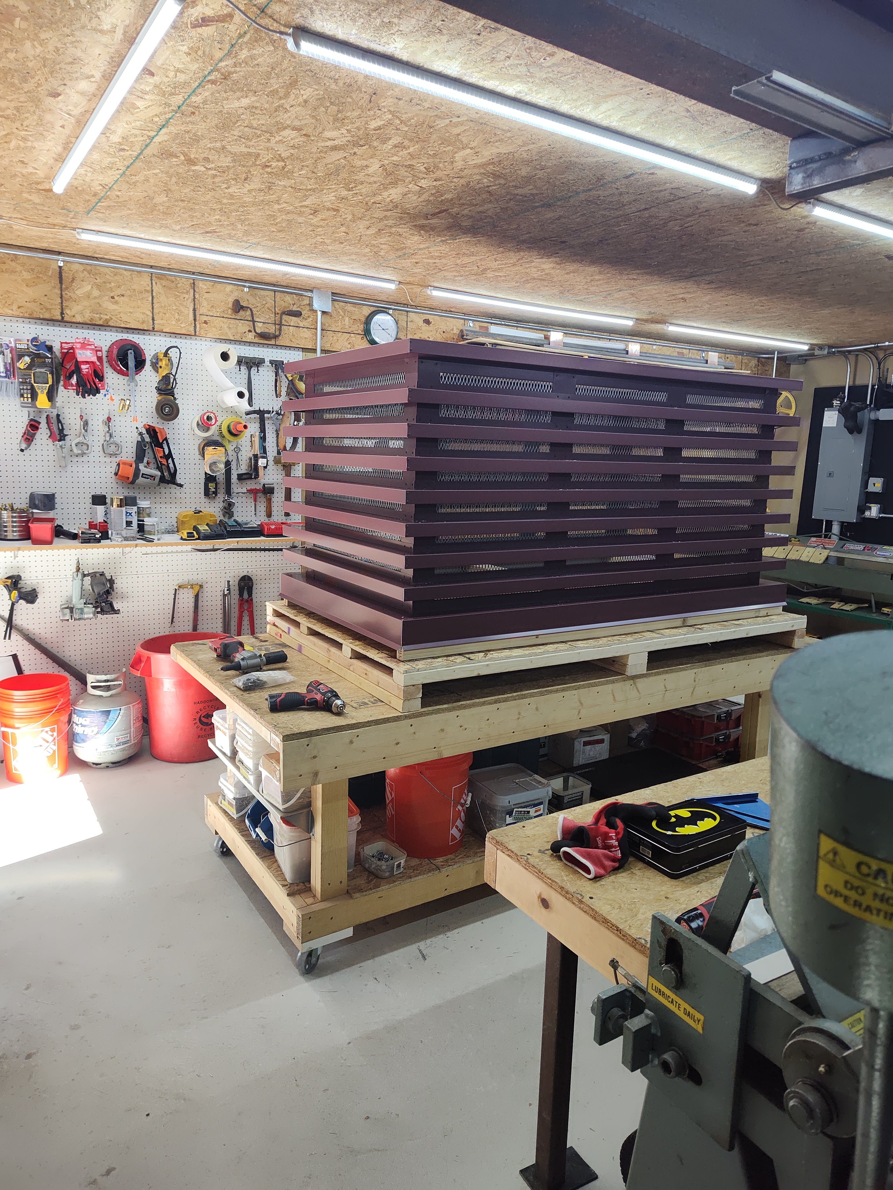 Custom louvered chimney caps in Kynar finish stacked in workshop — handcrafted by Archaic Metal