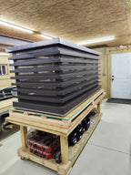 Custom louvered chimney caps with stainless steel spark screens stacked in Archaic Metal shop