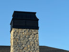 Modern louvered chimney cap installed on stone masonry chimney — black Kynar aluminum custom fabricated by Archaic Metal, Berlin NJ