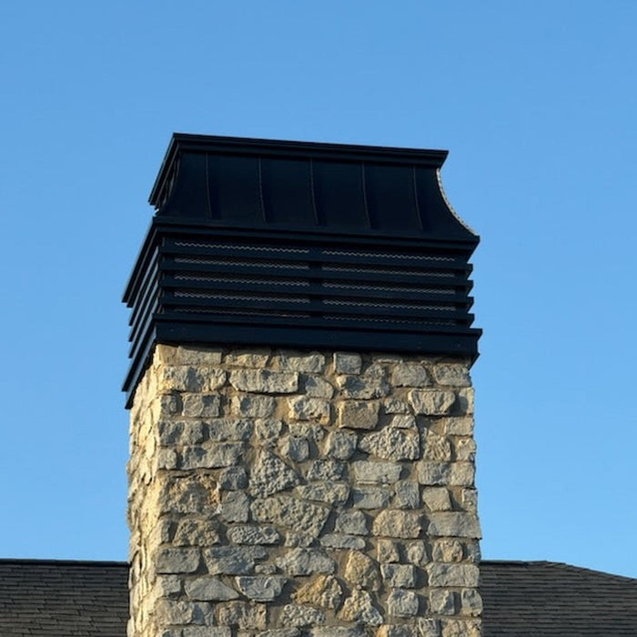 Modern louvered chimney cap installed on stone masonry chimney — black Kynar aluminum custom fabricated by Archaic Metal, Berlin NJ
