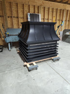 Custom modern louvered chimney cap in black Kynar aluminum — stepped fascia, curved panel sides, crown detail, and solid removable lid, fabricated by Archaic Metal