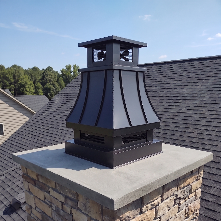 Custom Kynar Aluminum Black top vent chimney cap installed on stone masonry chimney — .032 Kynar finish, two-piece vented design, top mount, fresh matte black color, blue sky